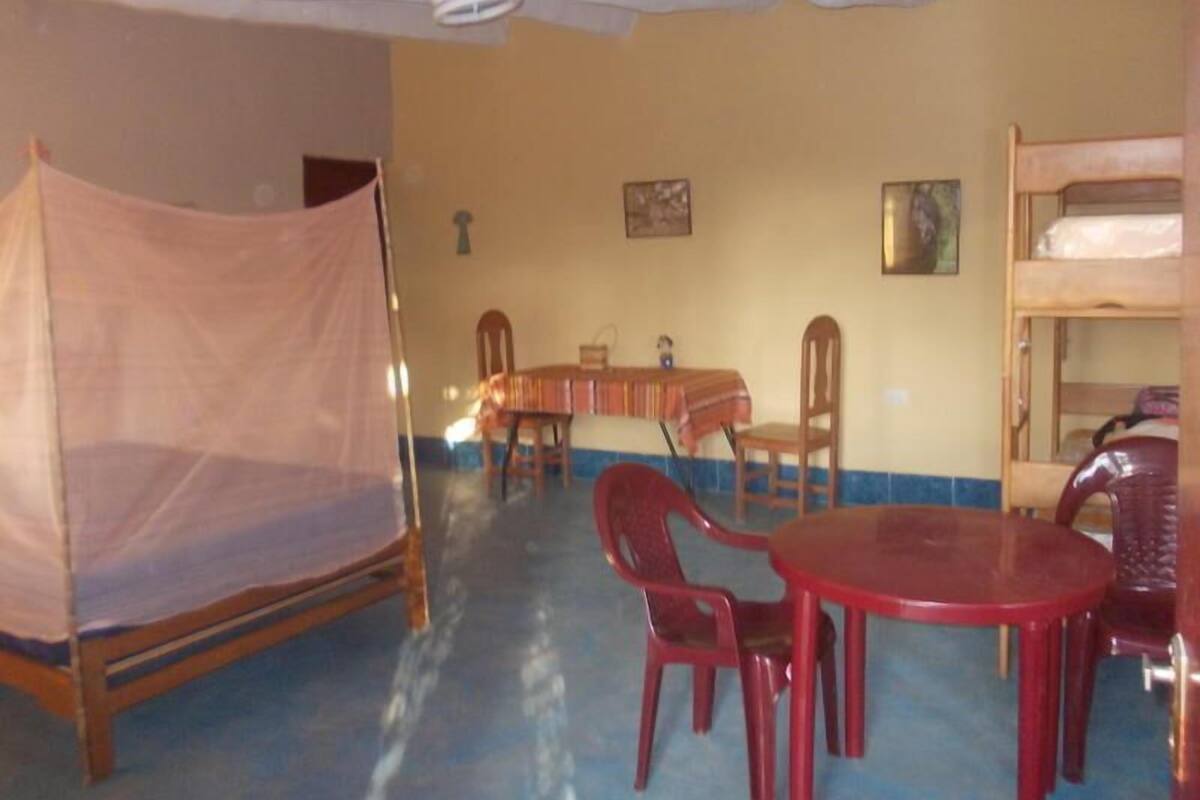 Een kamer met een bed, een tafel en stoelen.