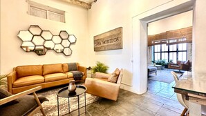 A living room with a sofa, a coffee table, and a rug. There is a sign on the wall that reads "CASA MORELOS". - Baja House (Todos Santos)