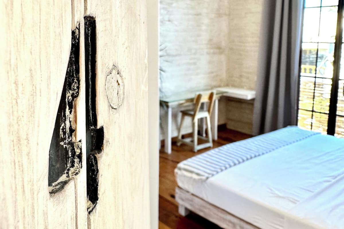 Ein Schlafzimmer mit einem Bett, einem Schreibtisch und einem Deckenventilator.