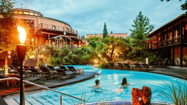 A swimming pool with lounge chairs and a staircase leading to a building.