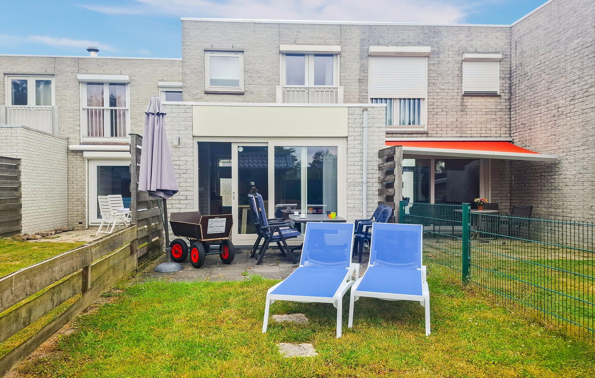 Ein Innenhof mit Terrassenbereich, Sitzgelegenheiten im Freien und einem Gebäude mit Ziegelaußenwand.