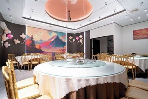 Un salón de conferencias con una mesa redonda de vidrio, varias sillas y un cuadro grande en la pared.