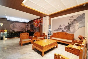 Un hall con muebles de madera tradicional, un mostrador de recepción y un mural.