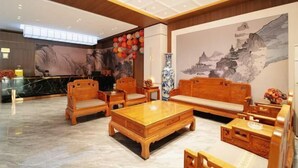 Un vestíbulo con muebles de madera, un mostrador de recepción y un mural grande.