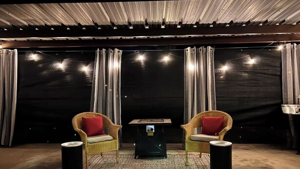 A room with two wicker chairs with red cushions, a small table, and two black speakers. - Cozy & Convenient Bungalow - Downtown & HPU (Brownwood)