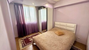 Quarto com uma cama grande, um espelho e um candelabro.