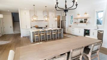 A spacious kitchen with a large island, pendant lighting, and white cabinetry.