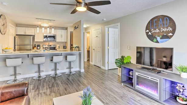 A modern kitchen with a bar area, a ceiling fan, and a sign that says "LEAD South Dakota". - Lead Condo w/ Patio: 14 Mi to Sturgis Rally (Lead)