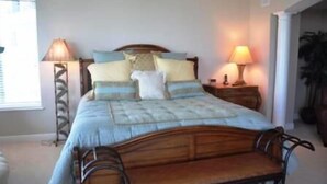 Un dormitorio con una cama, dos mesitas de noche y lámparas.