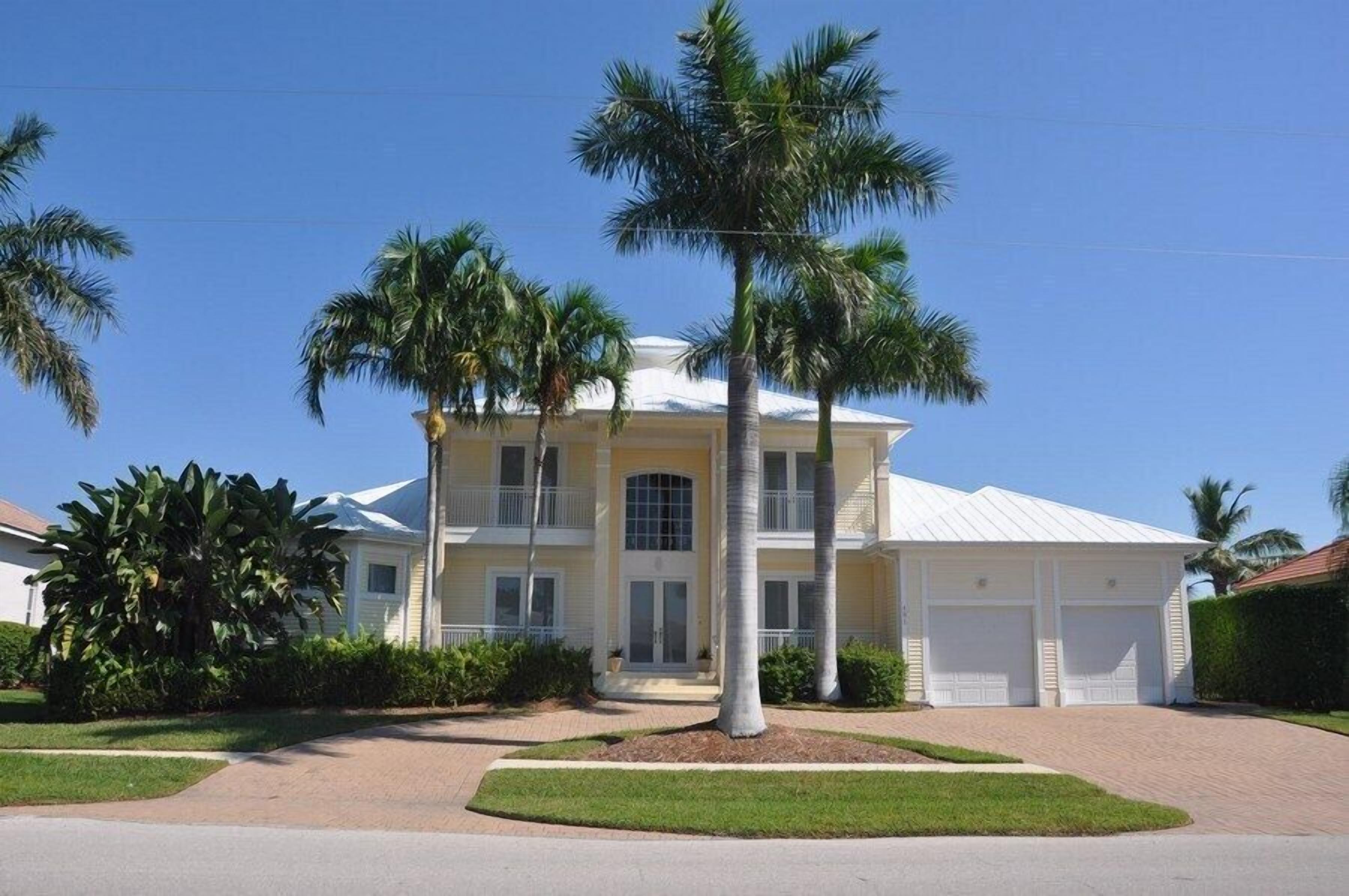 A two-story house with a white exterior, a front porch, and a garage.