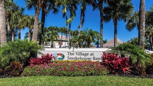 Une enseigne pour le complexe « The Village at Smokehouse Bay », agrémentée d’une végétation tropicale.
