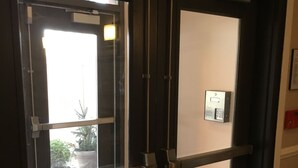 Una puerta con teclado de seguridad y una ventana.