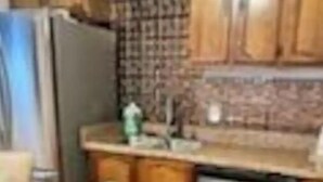 Una cocina con armarios de madera, un refrigerador de acero inoxidable y un lavavajillas.