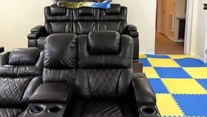 Una habitación con una silla de masaje, un cartel en la pared y un suelo a cuadros.