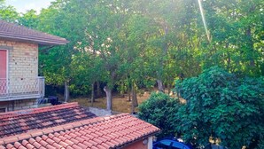 Un quartier résidentiel avec une maison à toit de tuiles, entourée d’arbres et de verdure.