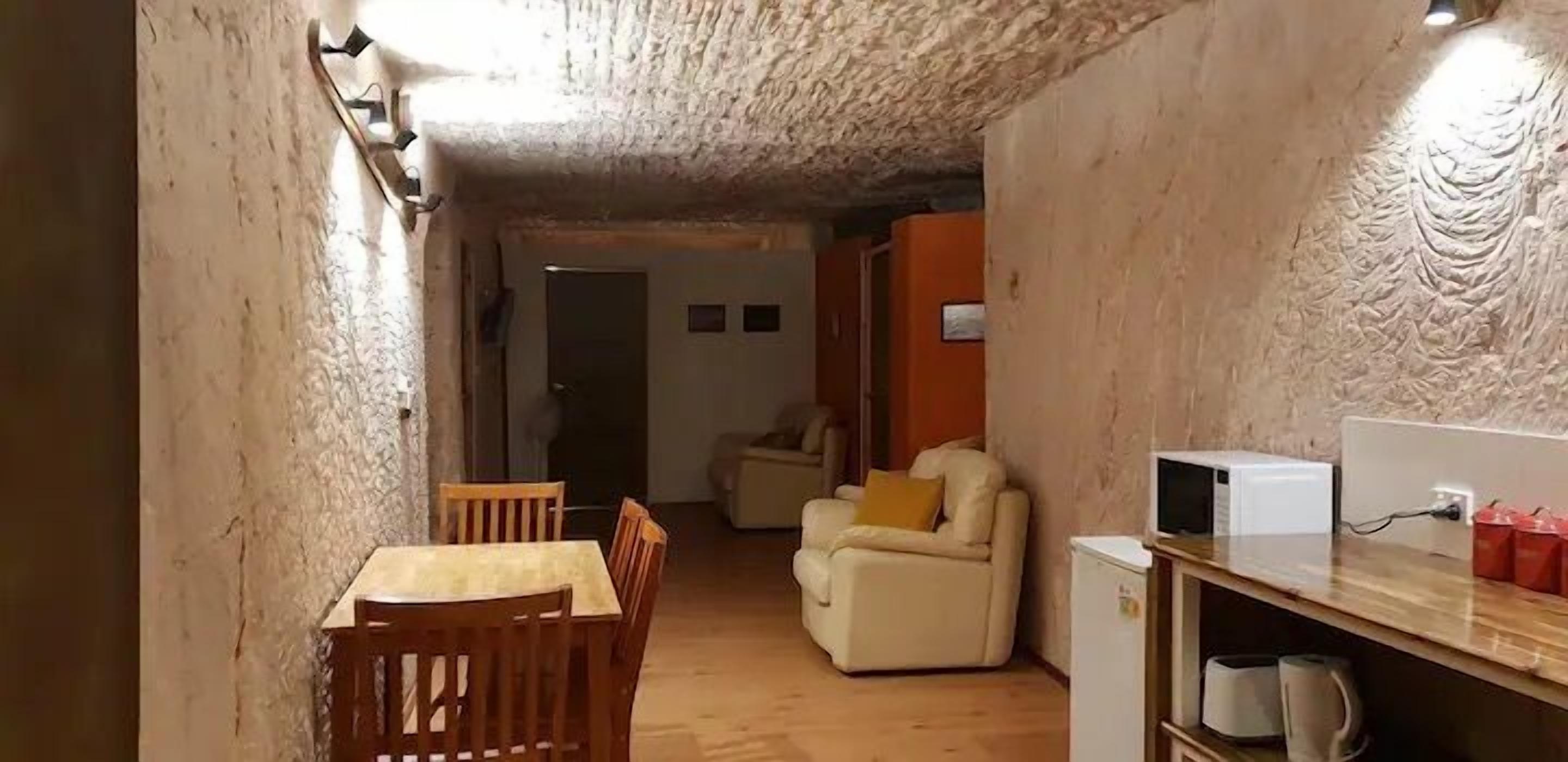 A compact living space with a dining area, a sofa, and a small kitchenette.
