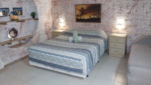 Ein Schlafzimmer mit einem großen Bett, zwei Nachttischen, einem Bild an der Wand und einem Regal mit Dekoration.