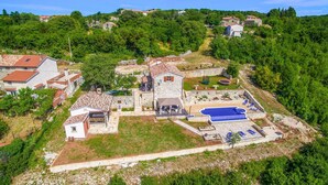 An aerial view of a property with a swimming pool, stone buildings, and a lush green landscape. - Beautiful home in Labin (Labin)