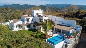 A modern villa with a swimming pool, multiple balconies, and a lush garden. - Private, ocean view, gourmet kitchen (Sayulita)