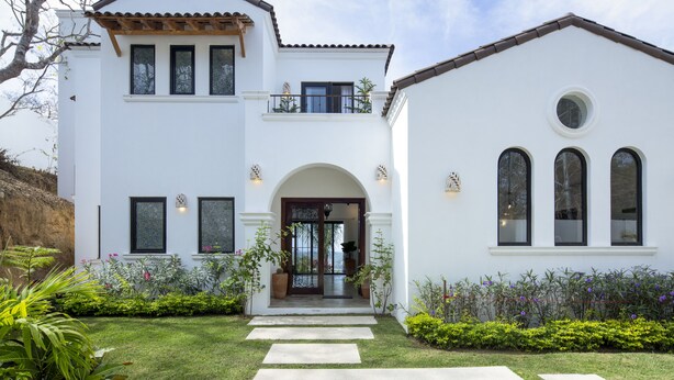 A two-story house with a white exterior, a balcony, and a front entrance with a glass door. - Private, ocean view, gourmet kitchen (Sayulita)