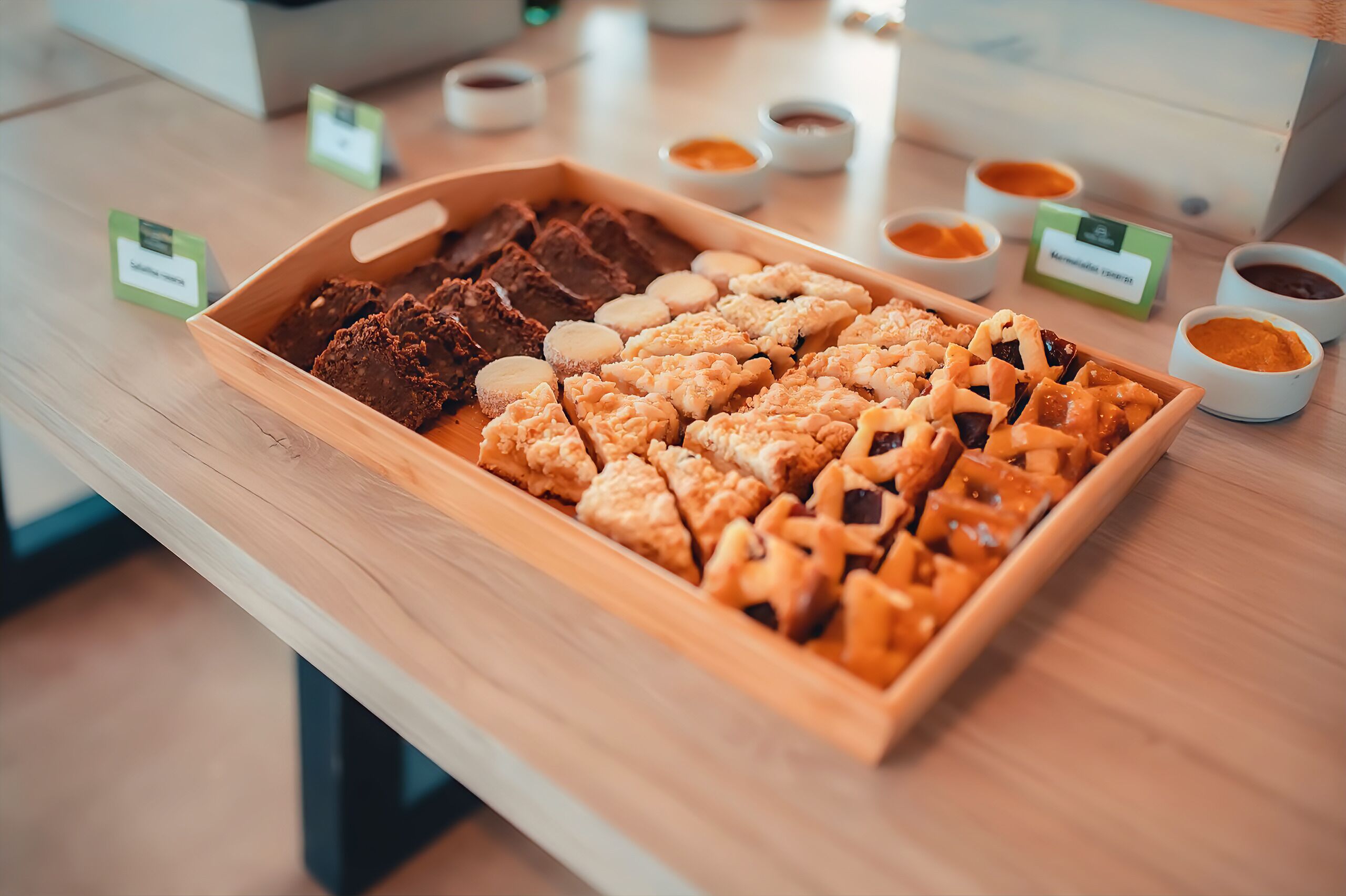 A tray of assorted baked goods with small bowls of sauces.