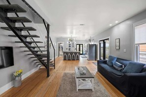 Ein modernes Interieur mit Treppe, Essbereich und Wohnzimmer mit Sofa und Couchtisch.