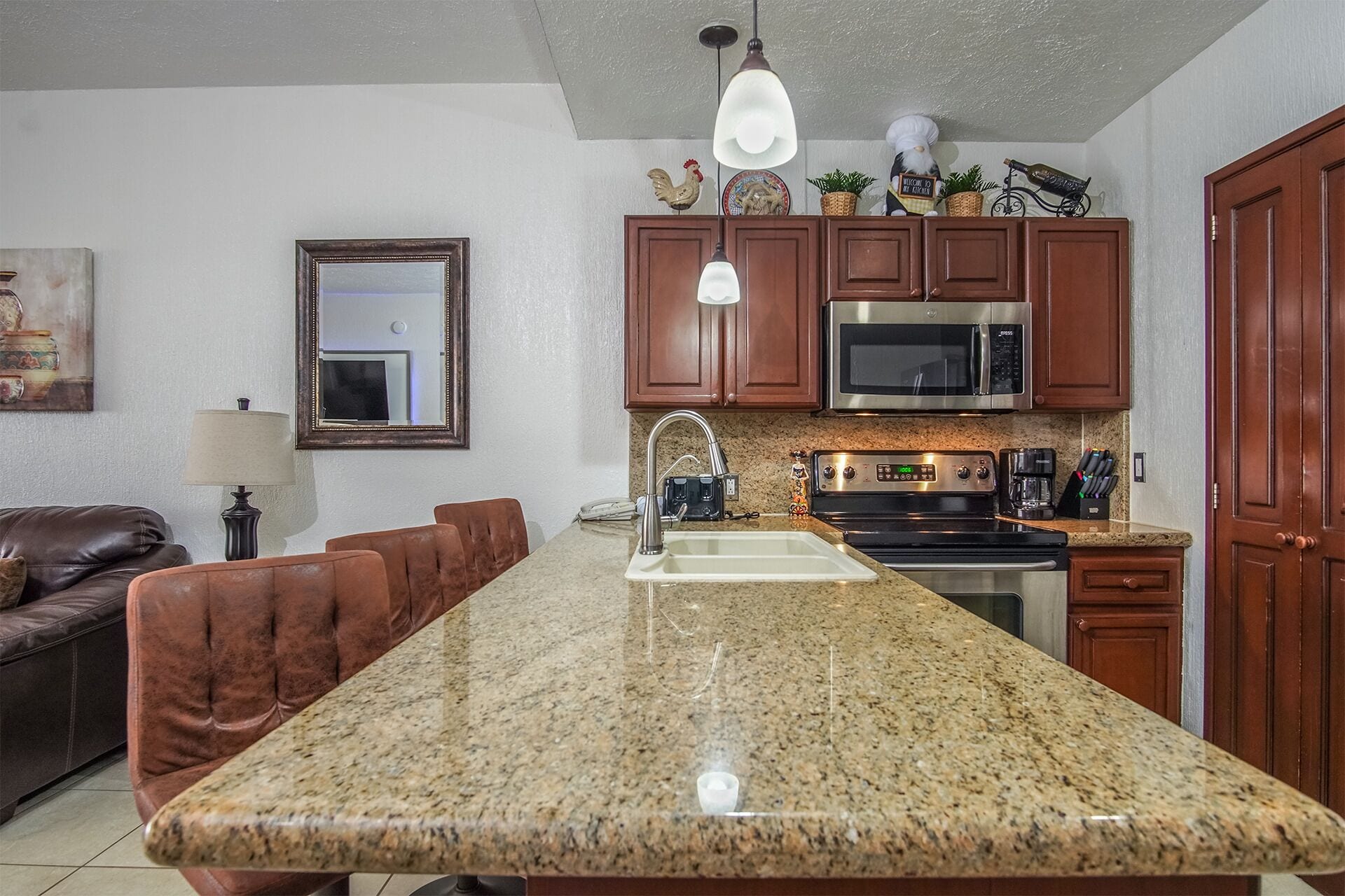 A kitchen with granite countertops, stainless steel appliances, and wooden cabinets.