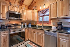 A kitchen with wooden cabinets, stainless steel appliances, a coffee maker, and a dish soap dispenser.