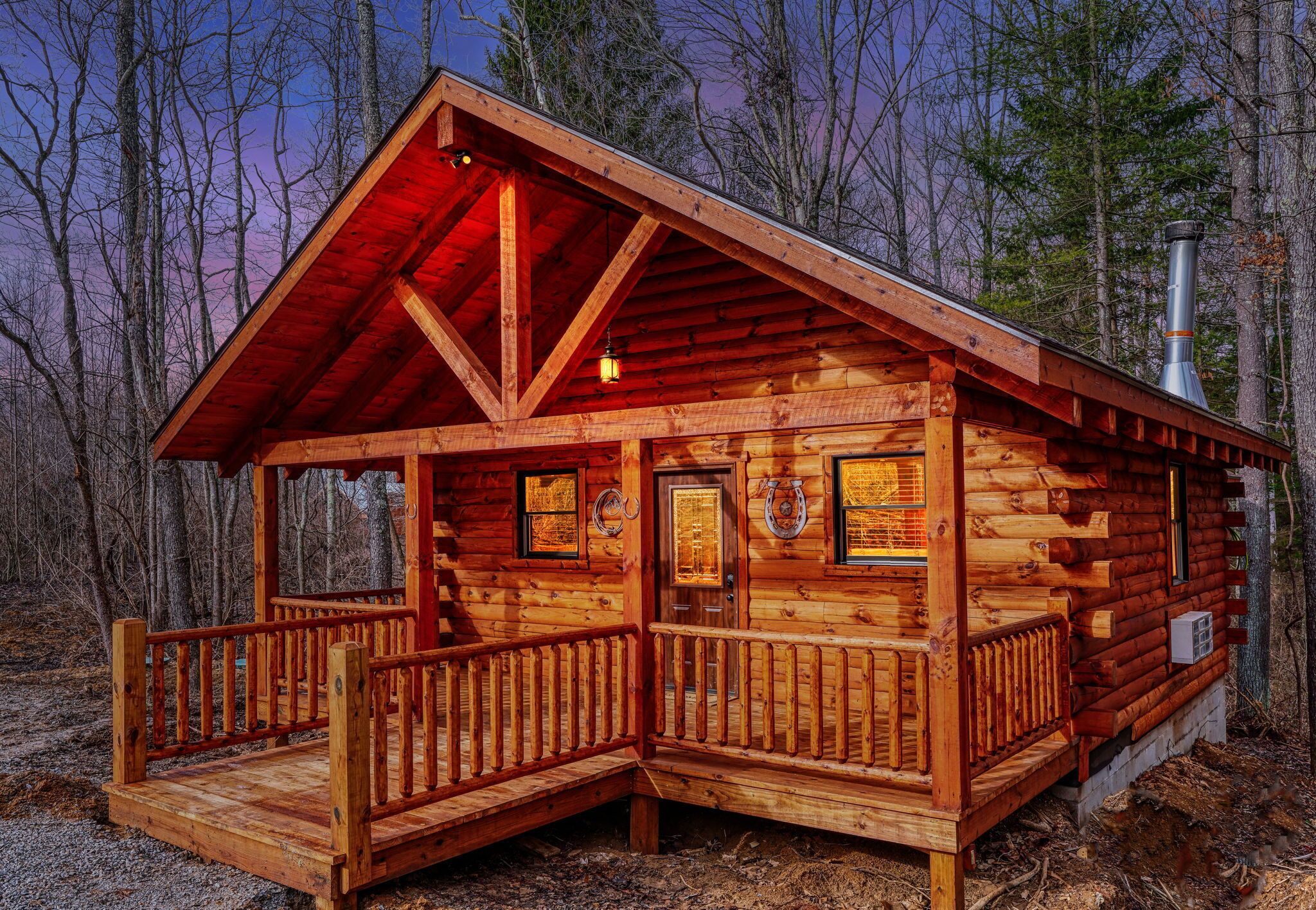 A log cabin with a porch, a chimney, and a door with a window.