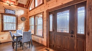 A wooden interior with a dining area, a clock, and a 'Welcome' sign. - Bluebonnet Luxury Cabin - in the Hocking Hills (Logan)