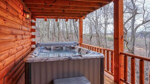 A wooden cabin with a hot tub on a deck. - Bluebonnet Luxury Cabin - in the Hocking Hills (Logan)