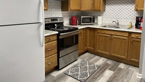A kitchen with wooden cabinets, a stainless steel refrigerator, a stove, an oven, a microwave, and a sink. - Loft apartment on Clifton, TN  Main Street Convenient, Cozy and Clean <br> (Clifton)