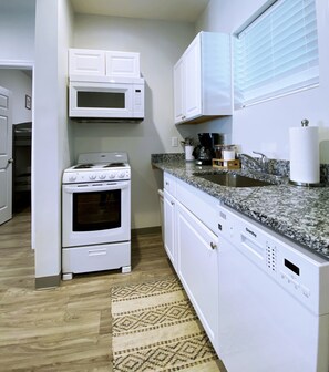 A kitchen with white cabinetry, a built-in microwave, a stove, and a dishwasher.