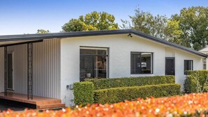A modern house with a covered porch, large windows, and a well-maintained garden. - "Eastside Haven" - Central & Convenient! (East Toowoomba)