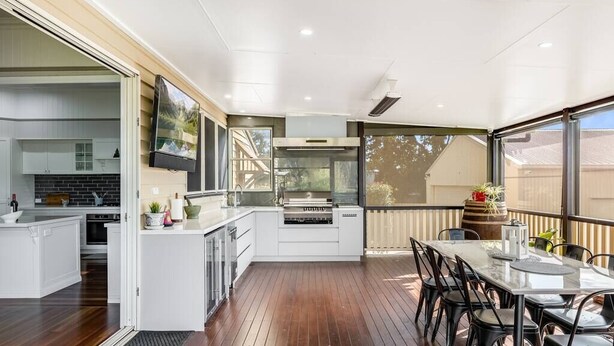 A modern kitchen with a built-in island, a dining area with a glass table, and a view of the outdoors. - Elegant, Stunning & Central! East Side Gem! (East Toowoomba)