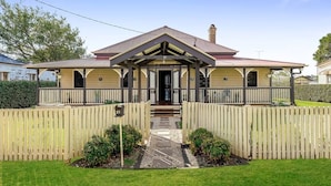 A two-story house with a front porch, a chimney, and a picket fence. - Elegant, Stunning & Central! East Side Gem! (East Toowoomba)