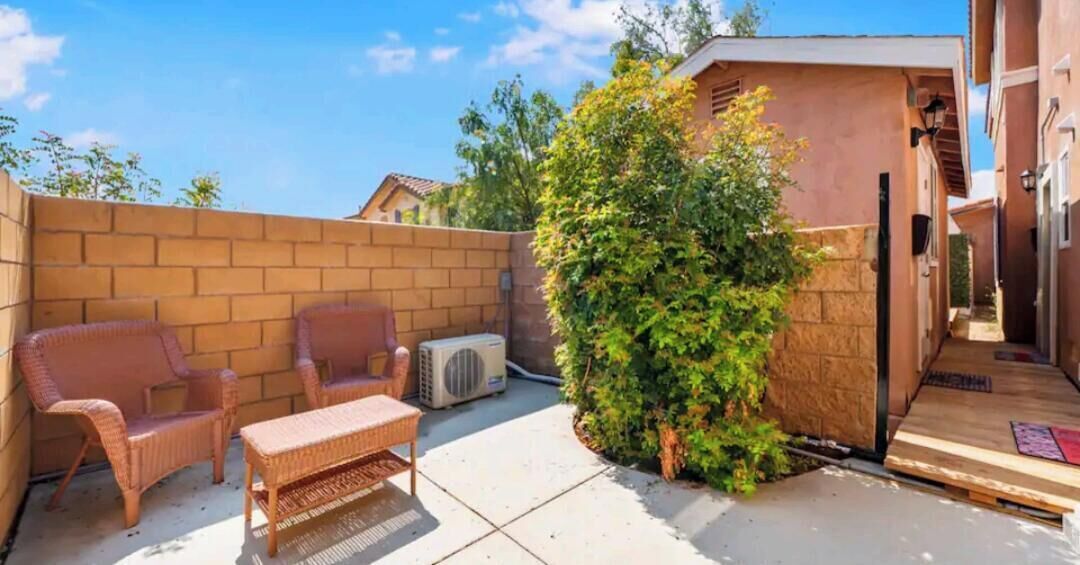 A patio with wicker furniture and a small table.
