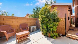 A patio with wicker furniture and a small table. - Private Studio (San Bernardino)