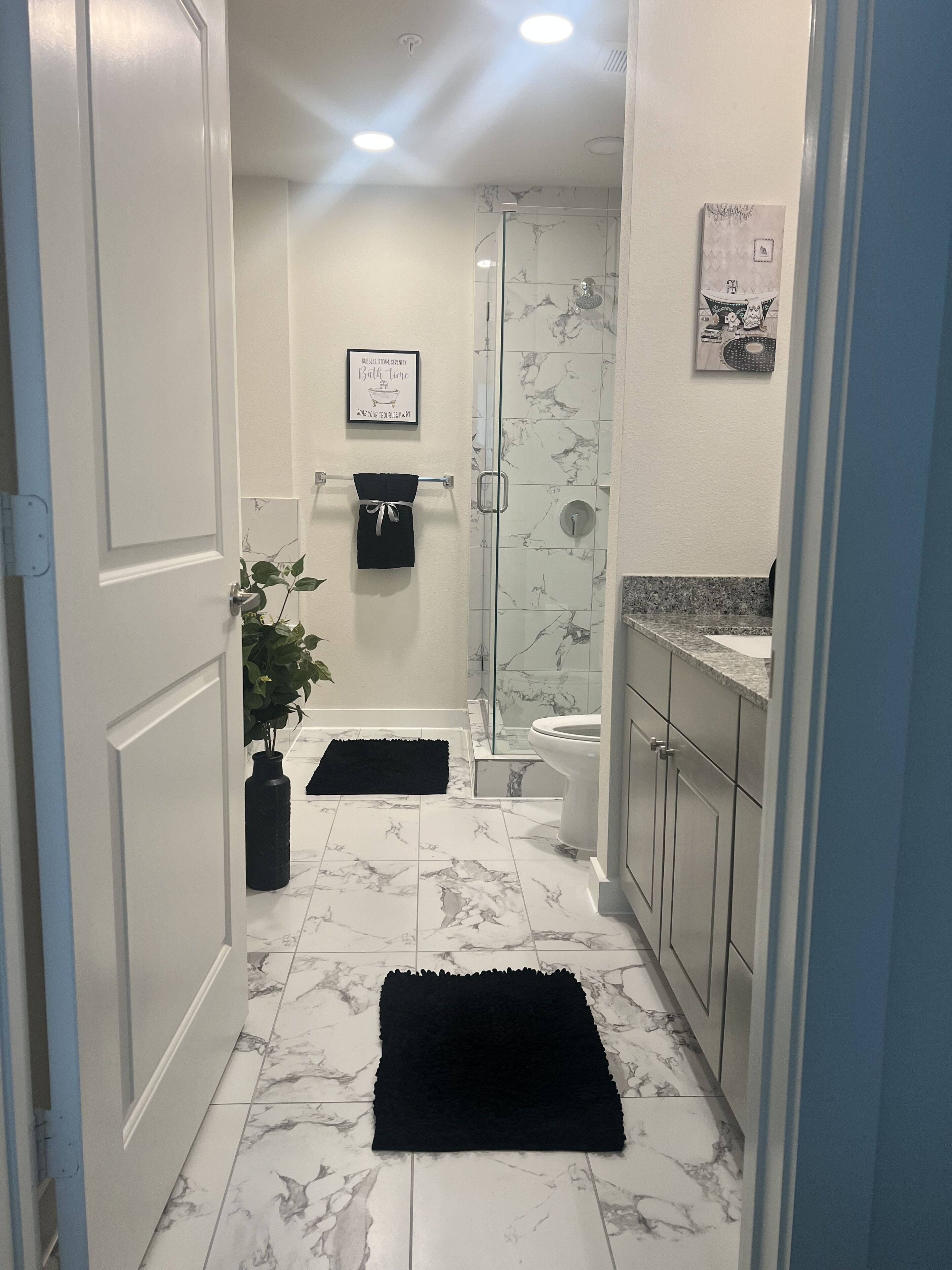 A bathroom with a shower, toilet, and a towel rack.