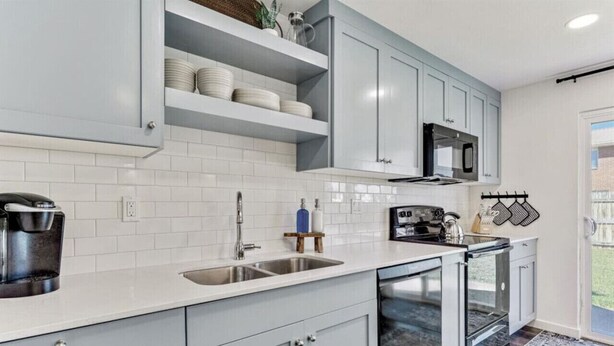 A modern kitchen with grey cabinets, white tiles, a built-in oven, and a coffee maker. - Sunset Paradise Retreat | 2 Hot Tubs | 2 Houses (Orem)