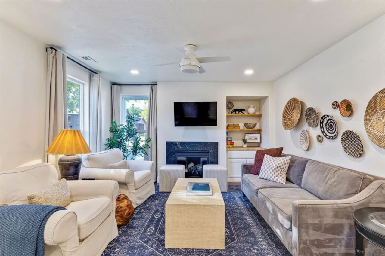 A living room with a fireplace, sofas, a coffee table, and decorative wall art.