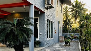 A building with a modern facade, a gravel pathway, and various potted plants. - Seaside home for families and furry friends! (Pranburi)
