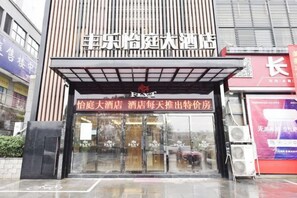 A hotel entrance with a modern facade, a prominent sign, and a glass door. - Fengle Yiting Hotel (Huangshan Yansi Scenic Area) (Huangshan City)