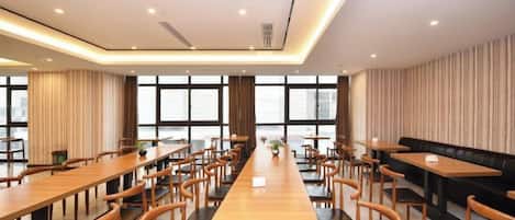 A conference room with a long table, multiple chairs, and a sofa.