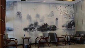 A room with a traditional mural, wooden furniture, and a modern ceiling design.