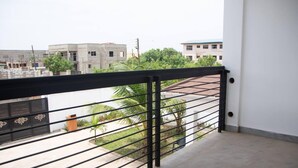 A balcony with a metal railing overlooking a residential area with buildings and greenery. - Luxuriously Finished 4-bed House in Tema Comm 25 (Tema)