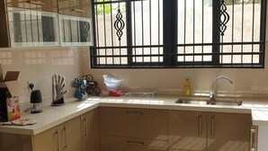 A kitchen with a window, sink, cabinets, and various kitchen items. - Luxuriously Finished 4-bed House in Tema Comm 25 (Tema)