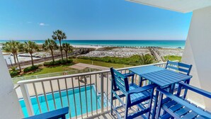 Ein Balkon mit Pool, Strandblick und Holzterrasse.