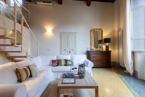 Relax in this inviting living space with a sofa, coffee table, and staircase leading to an upper level.