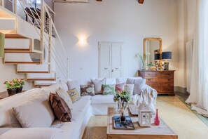 Relax in this stylish living room with a sofa, coffee table, and staircase.